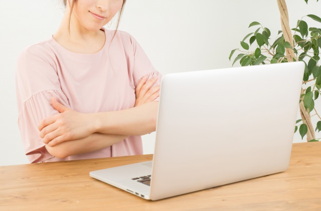 パソコンを前に考える女性(ウェブアクセシビリティのイメージ)